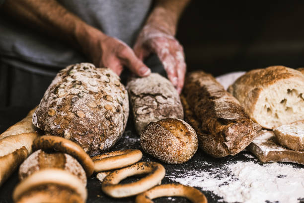 istock Baker man holding a rustic organic loaf of bread in his hands 1136678266