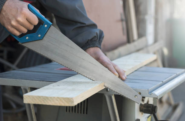 istock Carpenter cutting a board with a hand saw 1136679300