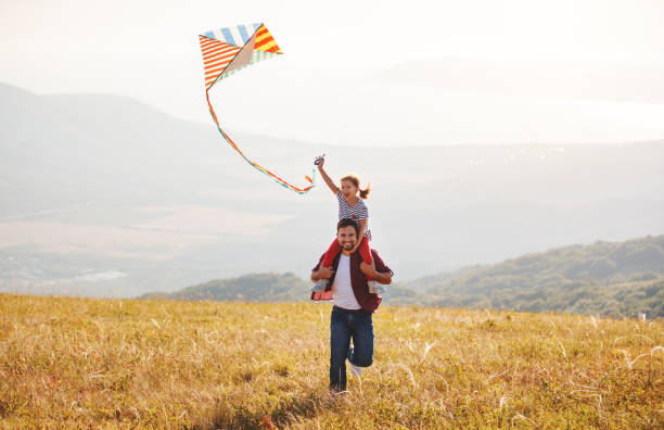lycklig familj far och barn dotter lansera kite på ängen - flying kite bildbanksfoton och bilder