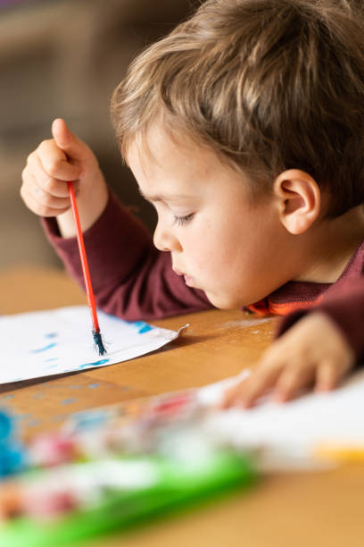istock Three years old child painting with watercolors 1136688918