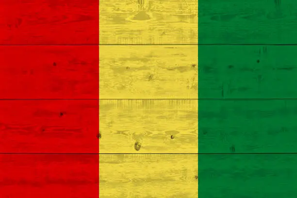 Photo of Guinea flag painted on old wood plank