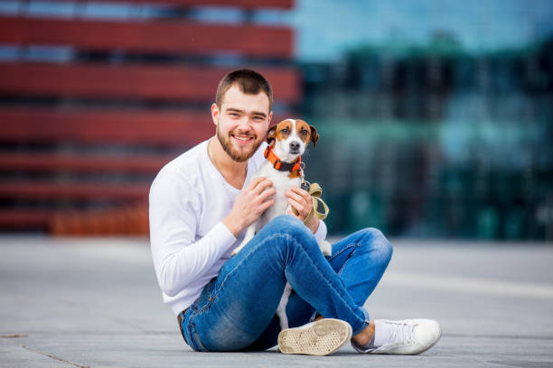 man with his dog, jack russell terrier, on the city street - terrier jack russell imagens e fotografias de stock