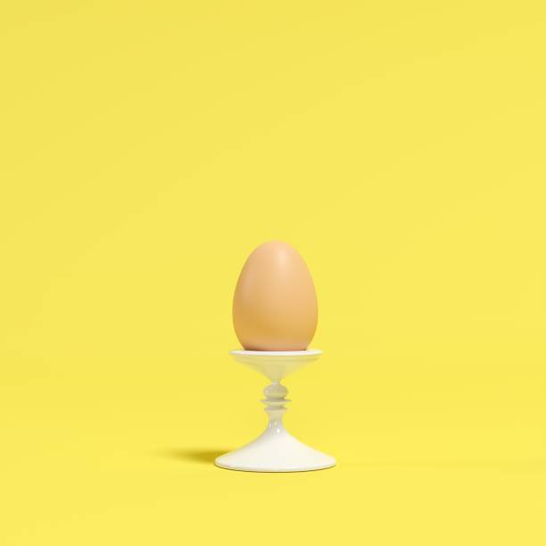 istock An egg on white dish on yellow background. minimal idea concept. 1136693872