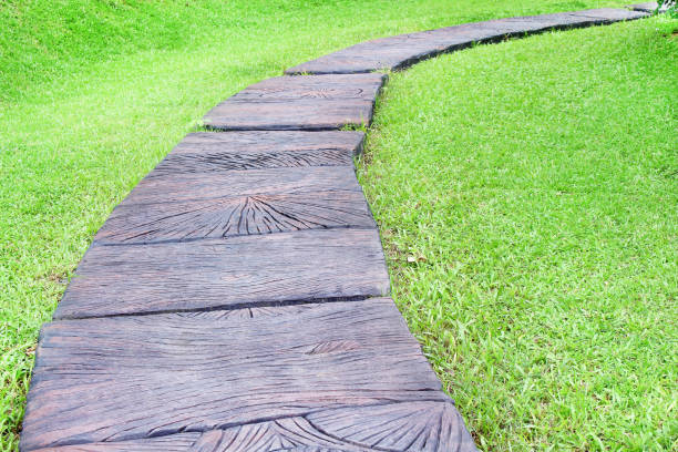 istock Brown concrete walkway with green grass in the park background 1136695105