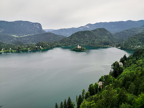 Lake Bled with The Mary church on Bled island. Sunlight reflects in the lake in a cloudy day.
