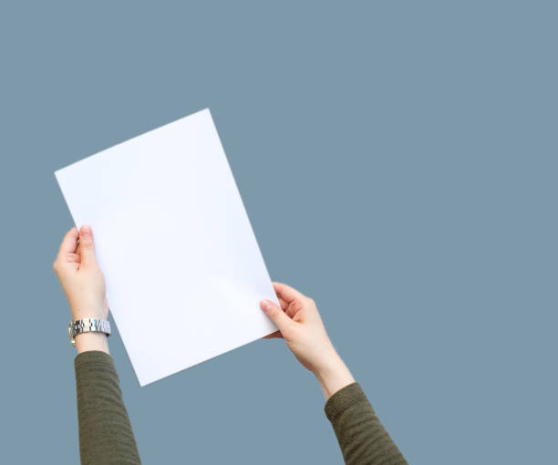 istock Female hands holding blank white paper 1136695887