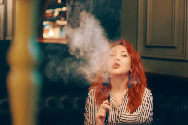 istock Young woman smoking hookah 1136695900