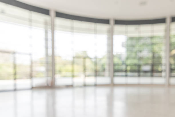 istock Blur background interior view looking out toward to empty office lobby and entrance doors and glass curtain wall 1136699224
