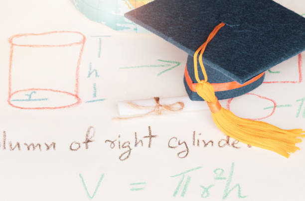 istock Graduation cap on paper math formula equation graph and blur of america earth world globe model map in Library of campus. Ideas for abroad international Educational for Studies lead to success in life 1136700958