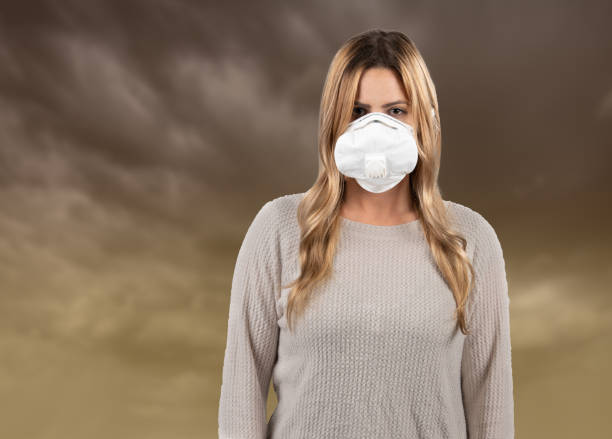 istock Woman wearing pollution mask with polluted sky 1136701101