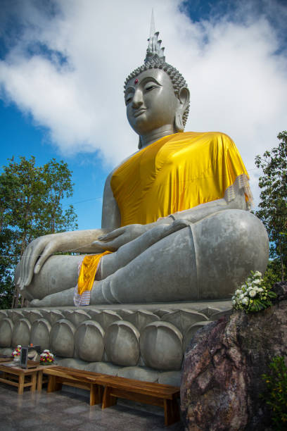 istock Beautiful big buddha statue sitting and blue sky background 1136703147