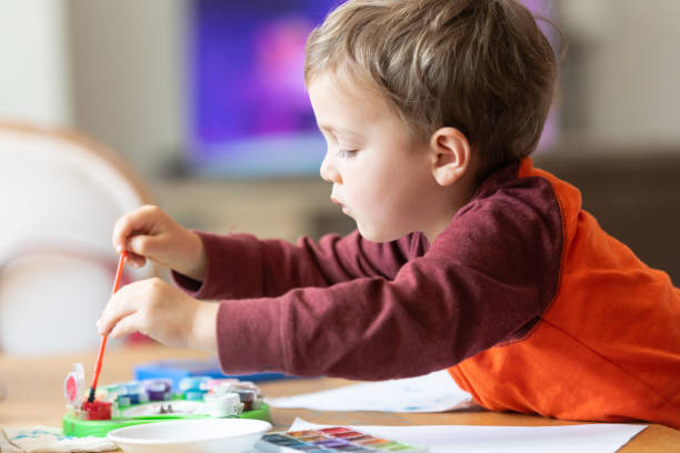 istock Three years old child painting with watercolors 1136704056