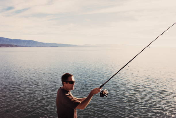 istock Man Coastal Fishing Off Rocks 1136709218