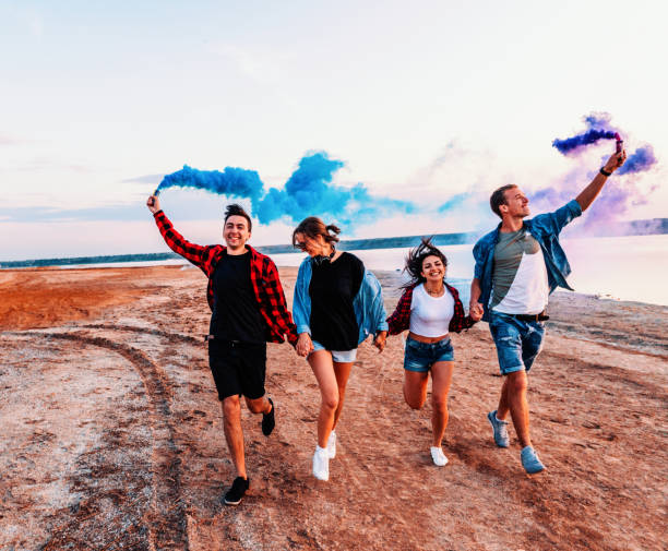 istock young friends running with hand flare or fusee 1136710798