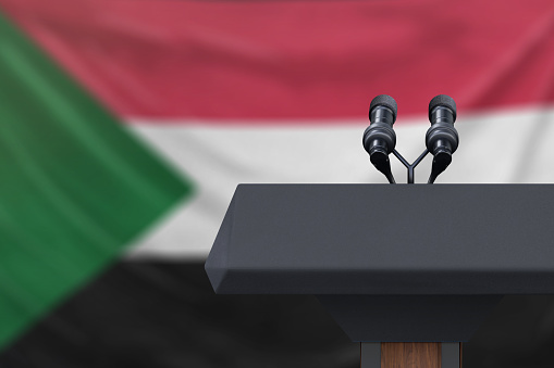 Podium lectern with two microphones and Sudan Sudan in background