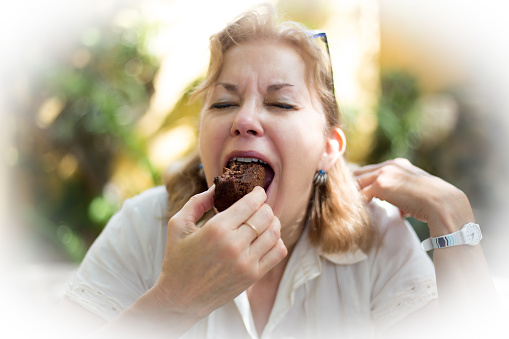 Woman Savoring Brownie; Mouth Open, Eyes Closed