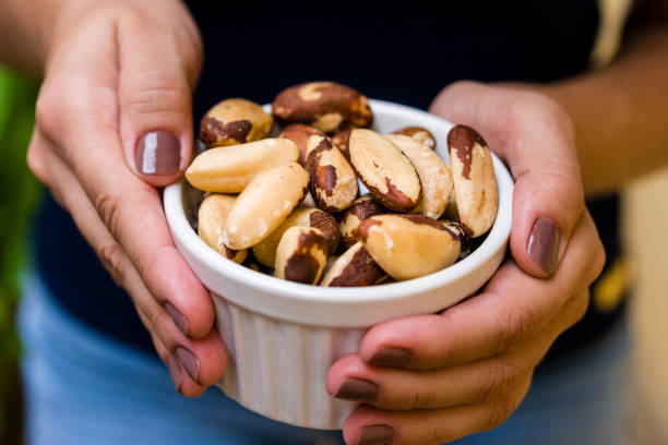 istock Brunette model hand holding white pot with brazilian nuts 1136728830
