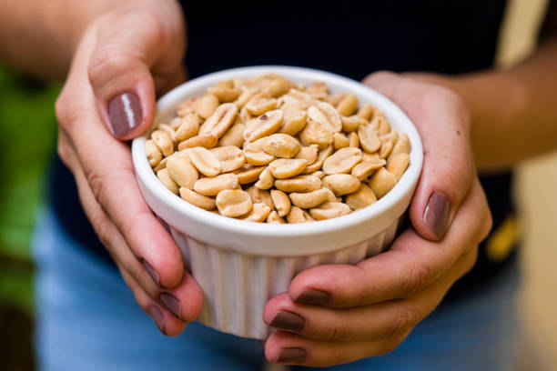 istock Brunette model hand holding white pot with roasted peanut 1136728836