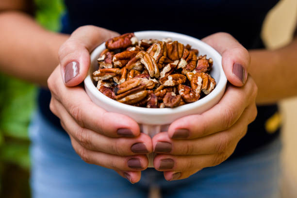 Peeled pecan nuts in bowl isolated on a white background.