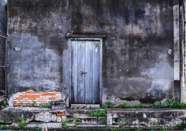 istock Vintage retro Home interior architectural design, plain old aged tropical weathered textured faded color wood panel board door and moldy wall of traditional Asian house. Background or backdrop concept 1136733904