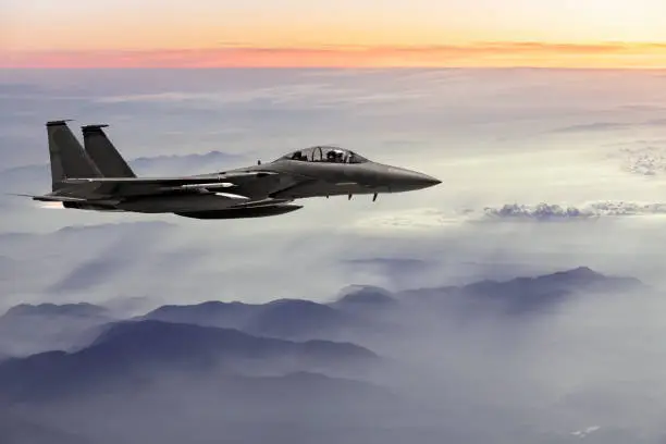 F-15 Fighter Jet flying at sunset