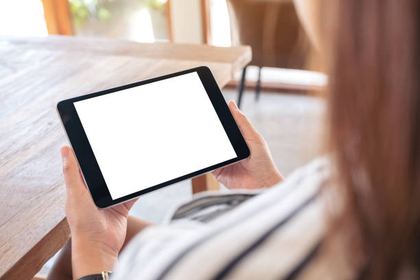 istock a woman sitting and holding black tablet pc with blank white desktop screen 1136747882