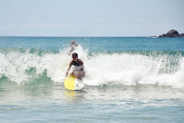 istock Young Child Learns to Surf at Beach 1136751253