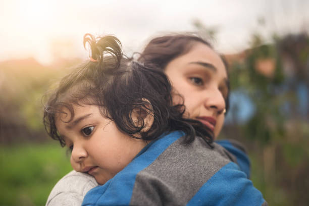 matriz triste que abraça sua filha pequena ao ar livre - asian ethnicity baby mother family - fotografias e filmes do acervo