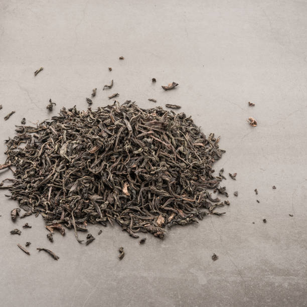istock Dried tea is poured scattered on a grey textured background. 1136752549