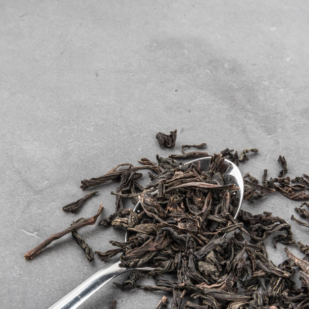 istock Dried tea and a spoon on a gray textured background. 1136752580