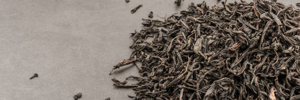 istock Dried tea is poured scattered on a grey textured background. 1136752601