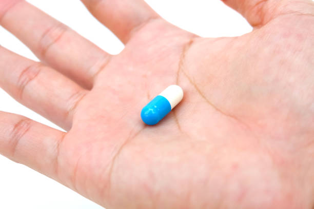 istock Blue white capsule of medicine on hand 1136752643