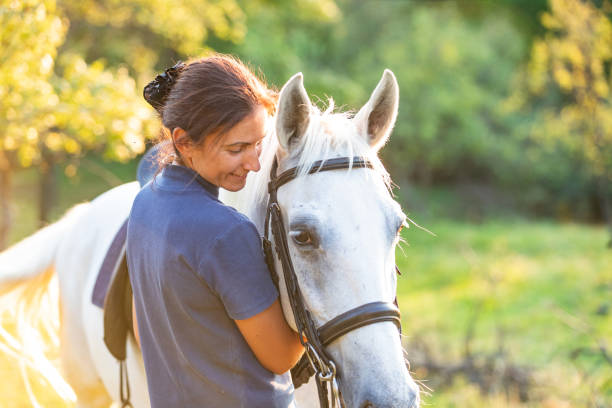 istock Woman hugging her white horse gently 1136753672