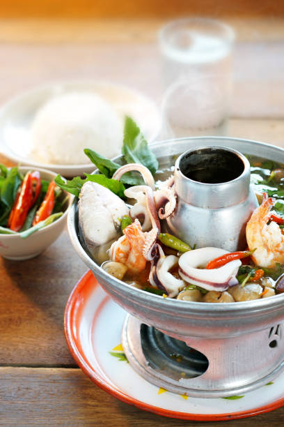 tom yam est une cuisine thaïlandaise populaire. soupe aigre aux fruits de mer, piment, champignons et herbes épicées. servi avec du riz cuit à la vapeur. focus sélectif. encore la vie shoot en studio, la nourriture propre bon goût concept idée. - sour taste green traditional culture lemon photos et images de collection