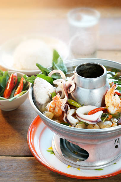 tom yam est une cuisine thaïlandaise populaire. soupe aigre aux fruits de mer, piment, champignons et herbes épicées. servi avec du riz cuit à la vapeur. focus sélectif. encore la vie shoot en studio, la nourriture propre bon goût concept idée. - sour taste green traditional culture lemon photos et images de collection