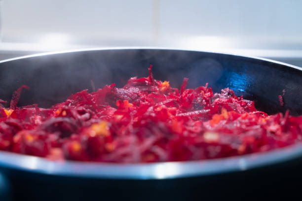 Roasting vegetables in a frying pan. Roasting beets with onions and carrots, close-up