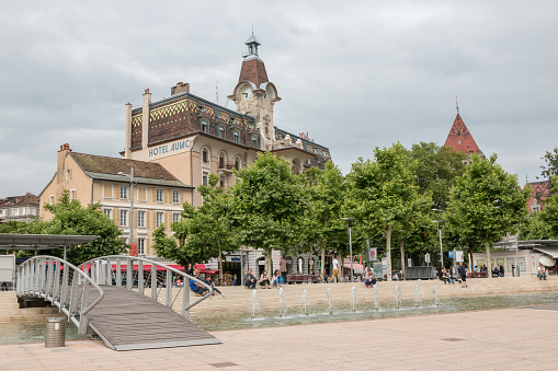 Lausanne, Switzerland - June 30, 2017: People relax on the waterfront of the Geneva lake in Lausanne Switzerland, Europe. Dramatic blue sky and summer landscape