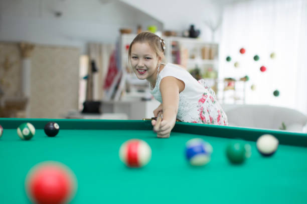 девушка играет в бильярд. дочь, играющая в бильярд - child sport playing pool game стоковые фото и изображения