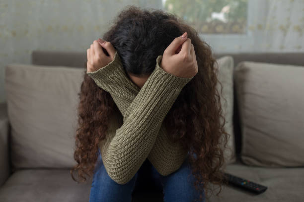 fille malheureuse sur le sofa - anxiety photos et images de collection