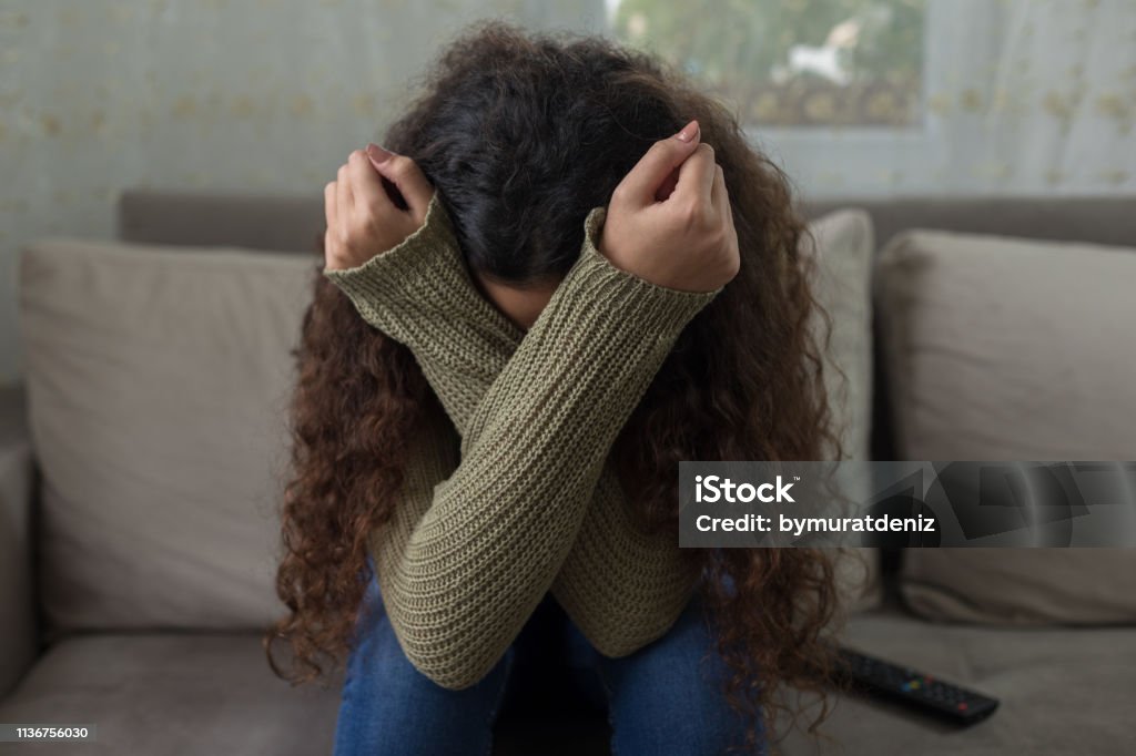 Unhappy girl on sofa Teenager Stock Photo