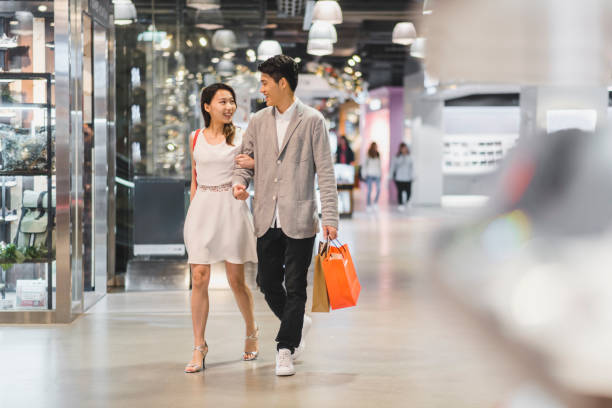 Young Chinese couple in the shopping centre Young Chinese couple in the shopping centre shopping asia stock pictures, royalty-free photos & images