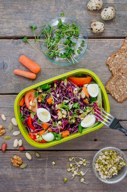 istock Lunch box with vegetable salad on rustic wooden background 1136764960