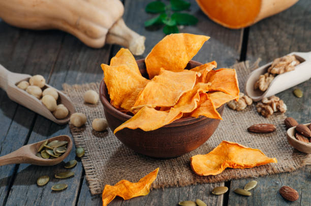 istock Dried pumpkin slices in brown ceramic bowl on rustic wooden background 1136765189