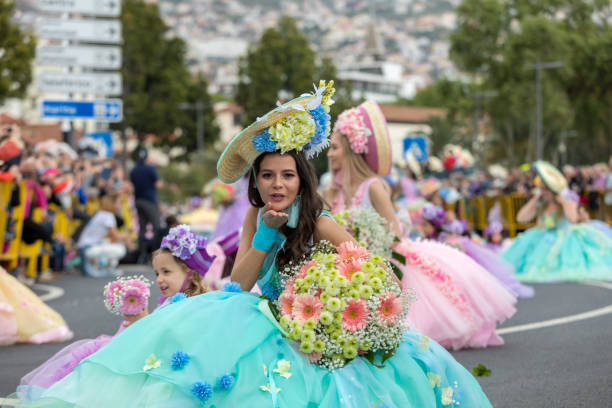 a group of people in colorful costumes are dancing at madeira flower festival parade in funchal on the island of madeira. portugal. - flower parade imagens e fotografias de stock