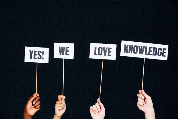 istock Four raised hands hold signs 