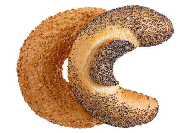istock Two crescent rolled buns with sesame and poppy seeds isolated on white background. Freshly baked bagels close-up. 1136770096