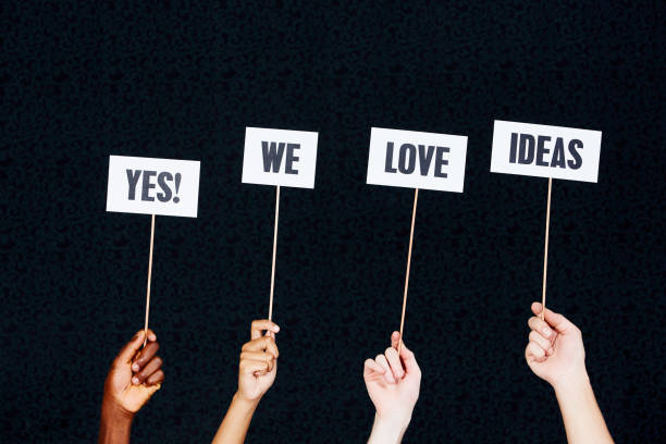istock Four raised hands hold signs 