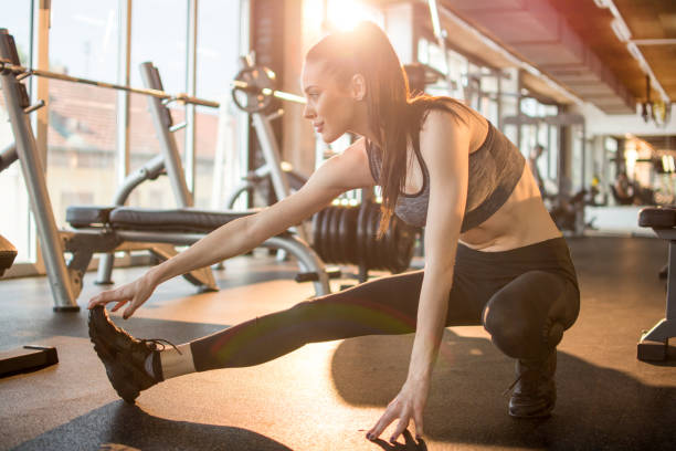 istock Attractive young sportswoman stretching at gym 1136771508