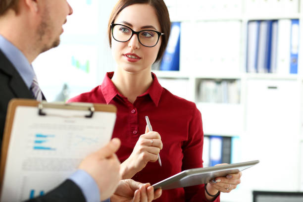 istock Businessmen and woman in glasses look and study statistics on electronic pad 1136775201