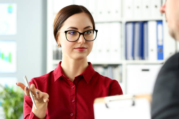 istock Beautiful smiling clerk wearing glasses with silver pen in arm 1136775204